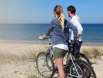 couple with bike at the beach
