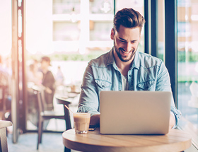 man on laptop in cafe