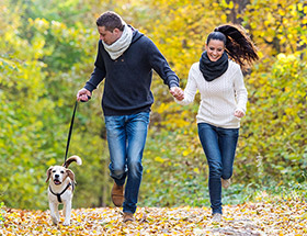Happy couple running with their dog