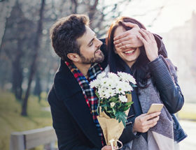 Man being a romantic partner and surprising his girlfriend with flowers