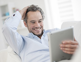 man looking at a tablet at home