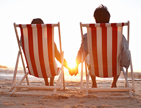 couple sitting on a beach holding hands