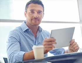 Handsome man using a dating app on his tablet