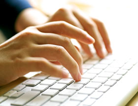 someone typing on a laptop sending a message