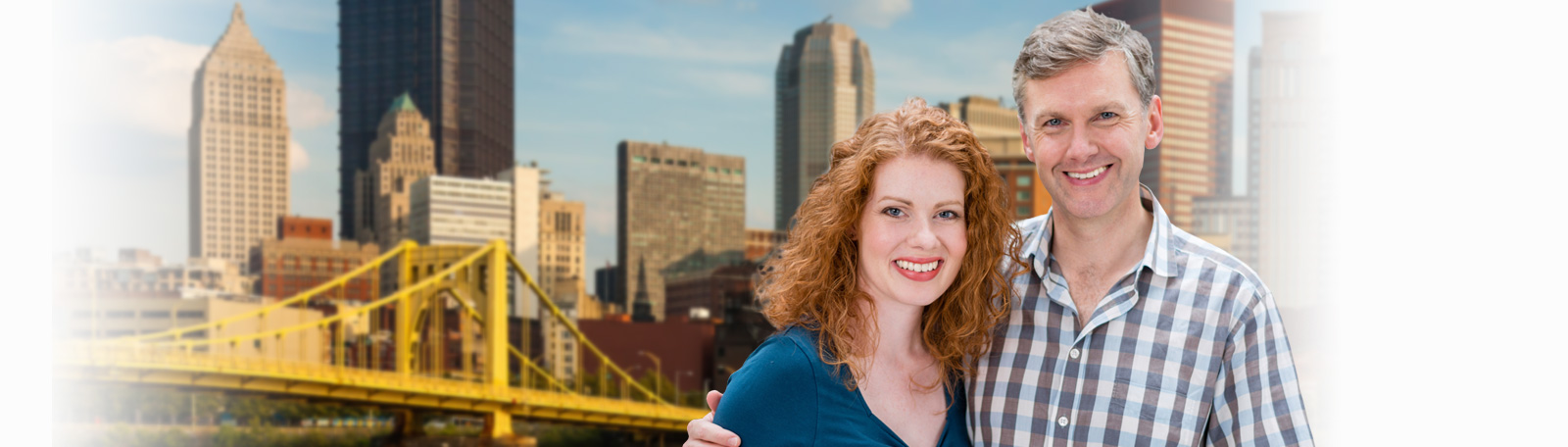 Couple standing in front of the Pittsburgh skyline