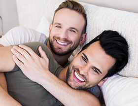 happy man in bed together with his boyfriend