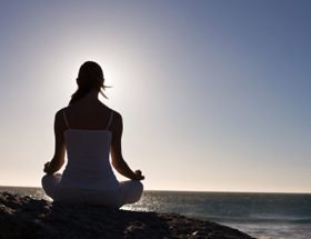 single woman meditates in yoga pose