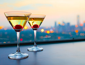 Two cocktails in martini glasses with maraschino cherries 