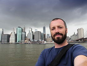 man taking a selfie by the Brooklyn Bridge