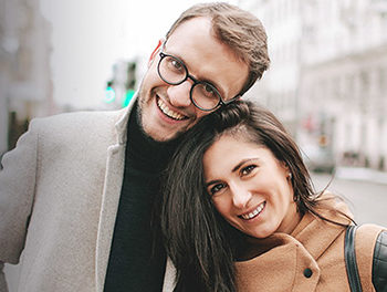 smiling couple standing on city street