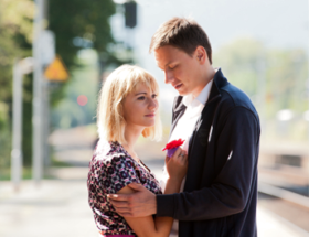 Couple having a sad goodbye hug in the street