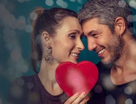 Happy couple smiling and embracing each other while enjoying a fun Valentine's Day date idea.
