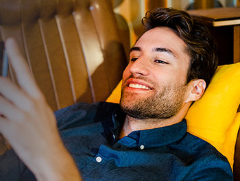 young handsome man replying to dating questions on his smartphone