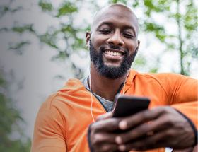 man on smartphone laughing at best opening lines for online dating