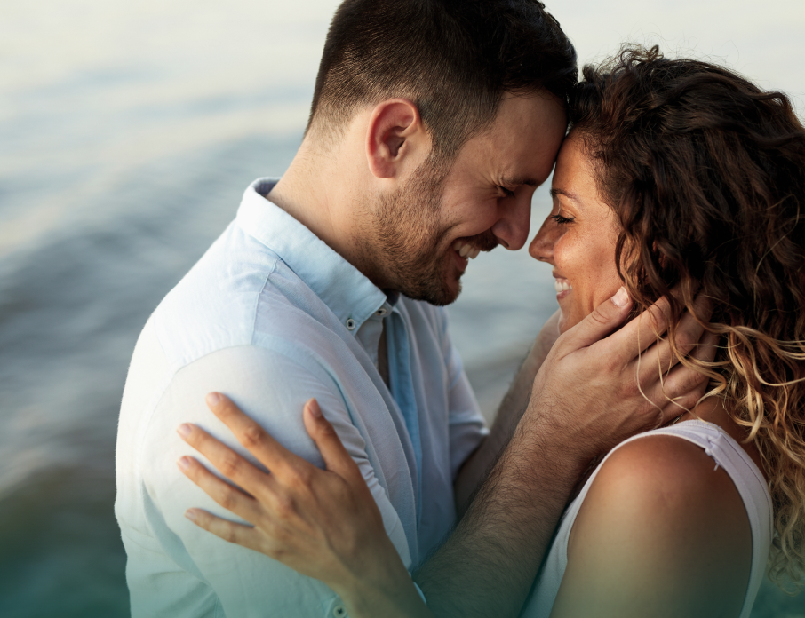 Happy couple embracing each other and looking deeply into each other's eyes while man is considering the question, is she the one?