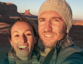 Two Utah singles smiling and taking a selfie while dating with Utah desert scenery in the background.