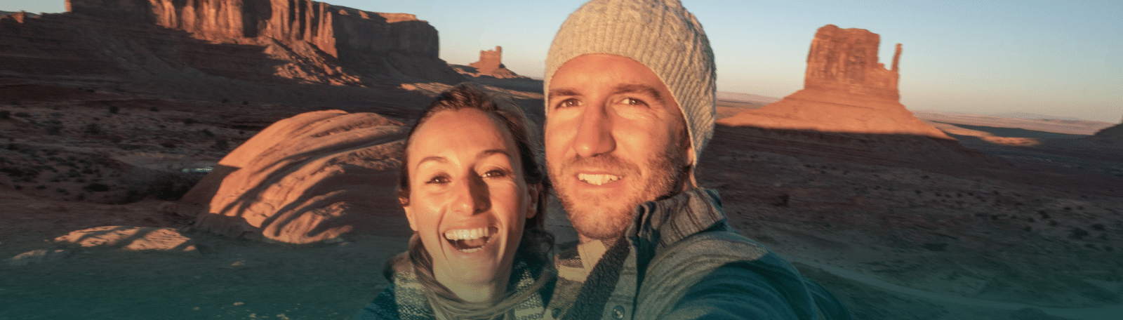 Two Utah singles smiling and taking a selfie while dating with Utah desert scenery in the background.