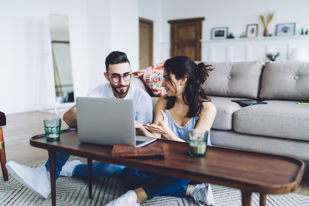 Young couple sitting on a sofa looking at a laptop.
